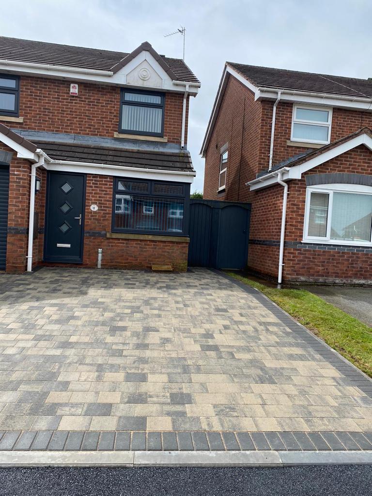 Buff and charcoal block paved driveway at a semi detached home