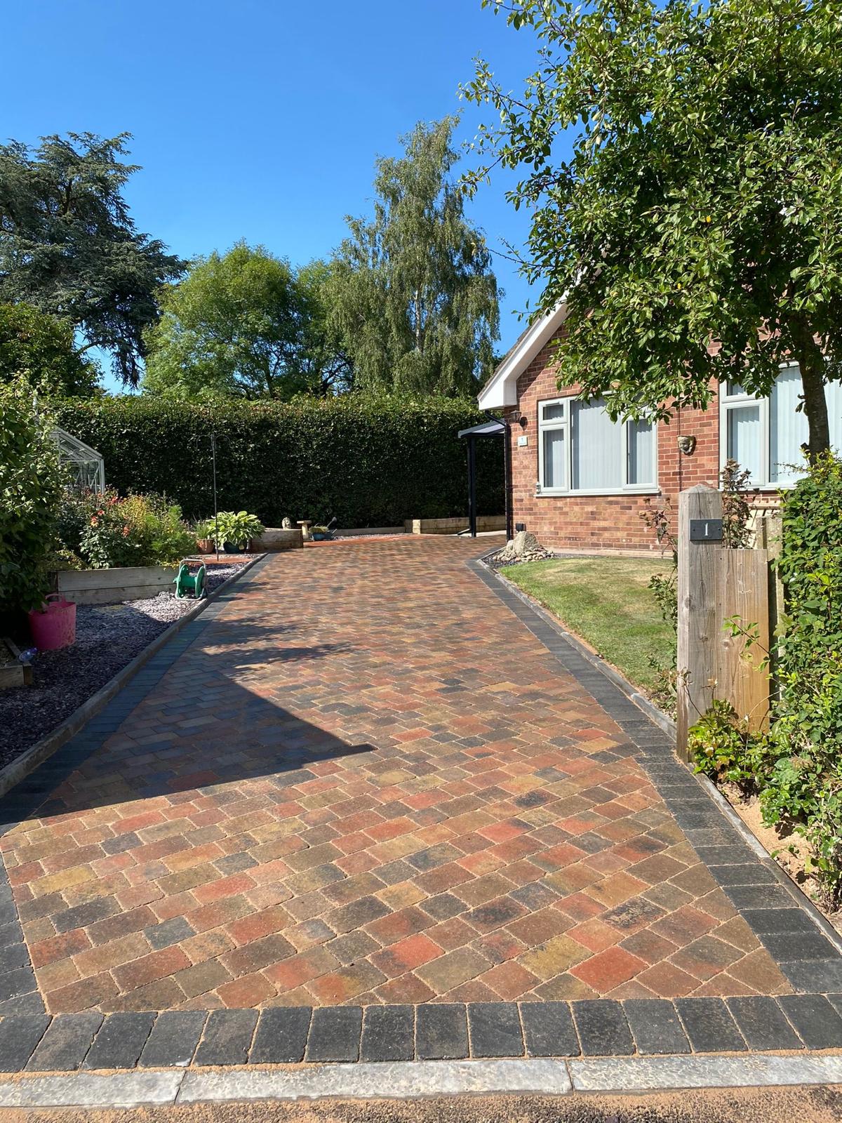 Long block paved driveway in autumn tones at a bungalow